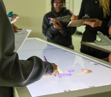 Students work on an interactive learning table