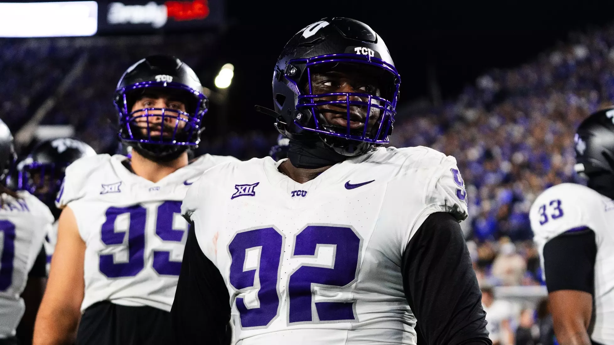 Photo of Ansel Din-Mbuh at an away football game. He is wearing the white TCU Football jersey, with the number 92 on it, and a black helmet with the TCU white logo on the side.